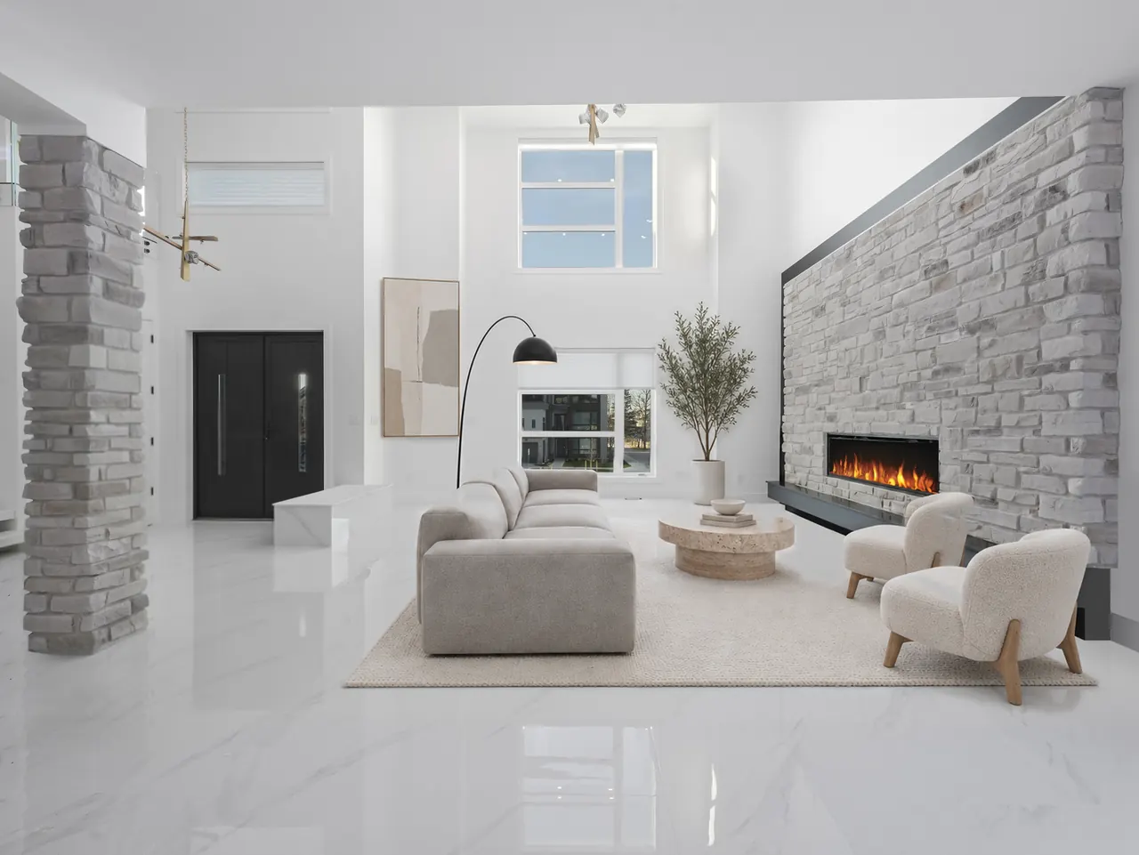Double-height great room with a stone fireplace wall, virtually staged with a sofa, two lounge chairs, an arc lamp and an olive tree